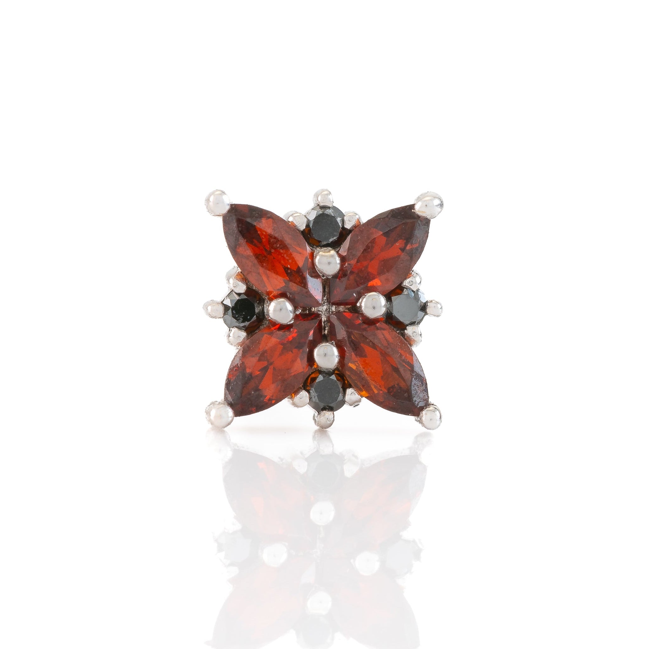 Star-shaped earring with red and black gemstones on a white background