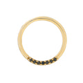 Gold ring with black gemstones on a white background