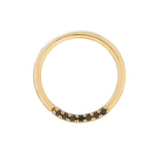 Gold ring with black gemstones on a white background