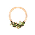 Rose gold ring with green gemstones on a white background