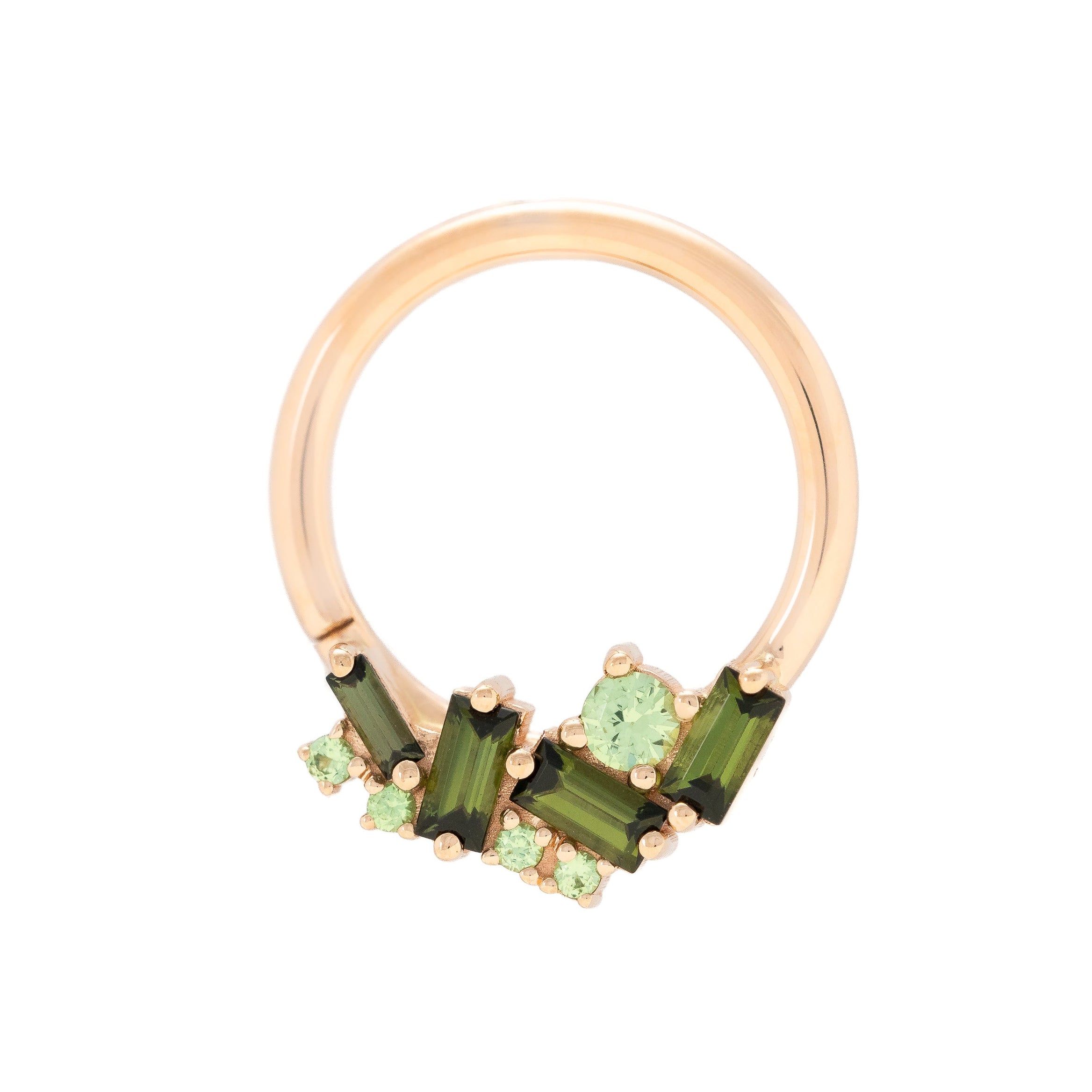 Rose gold ring with green gemstones on a white background