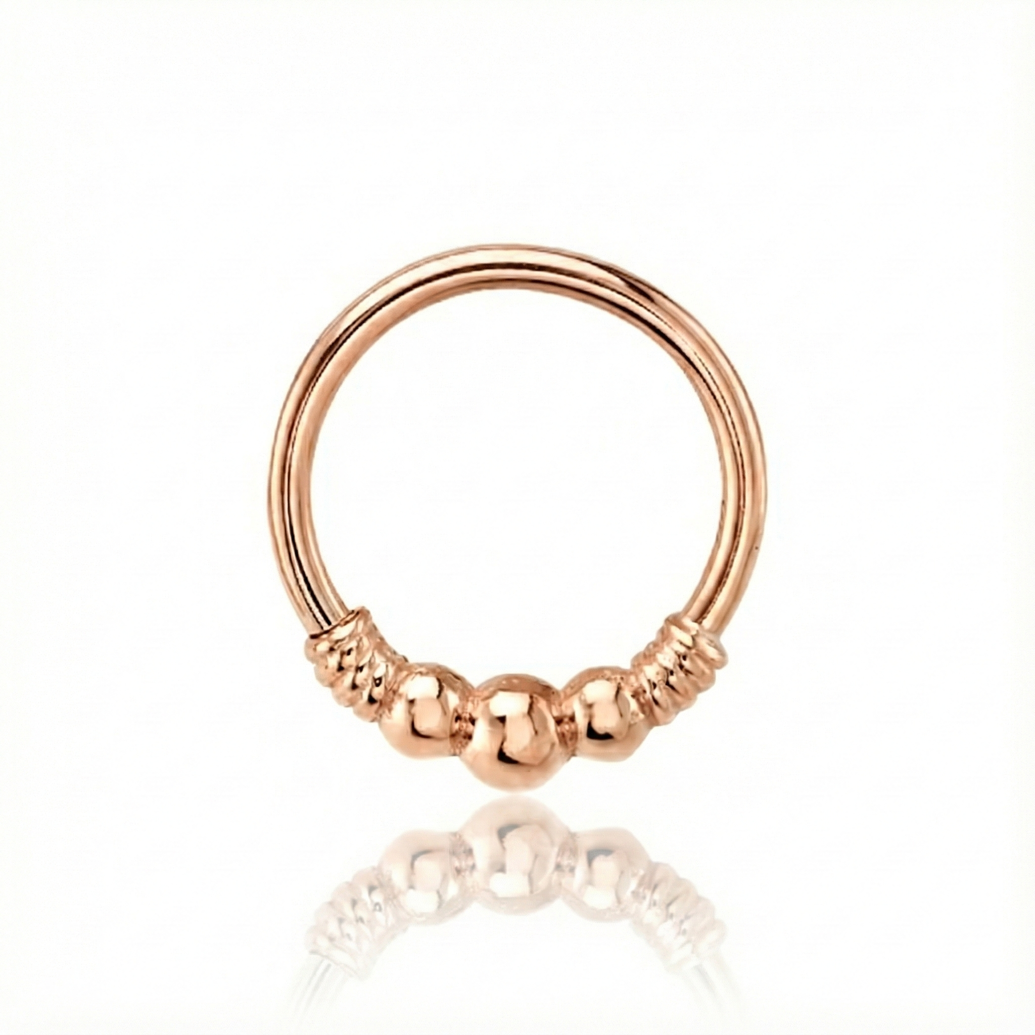 Rose gold nose ring with three beads on a white background