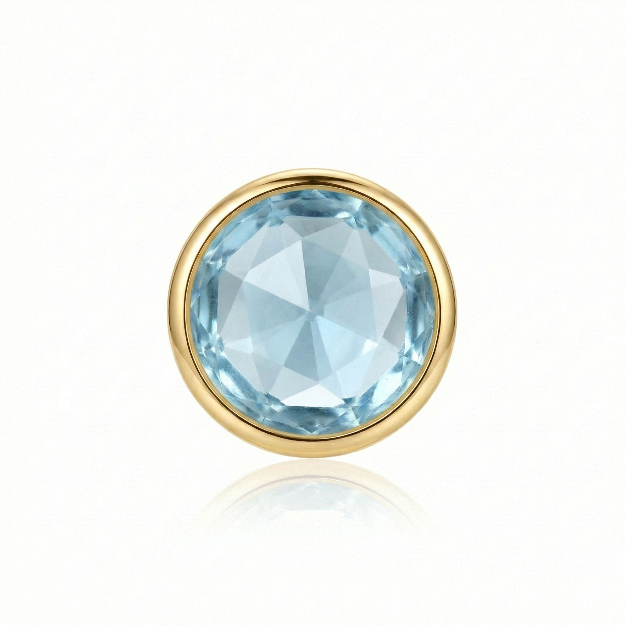 Blue gemstone set in a gold prong on a white background