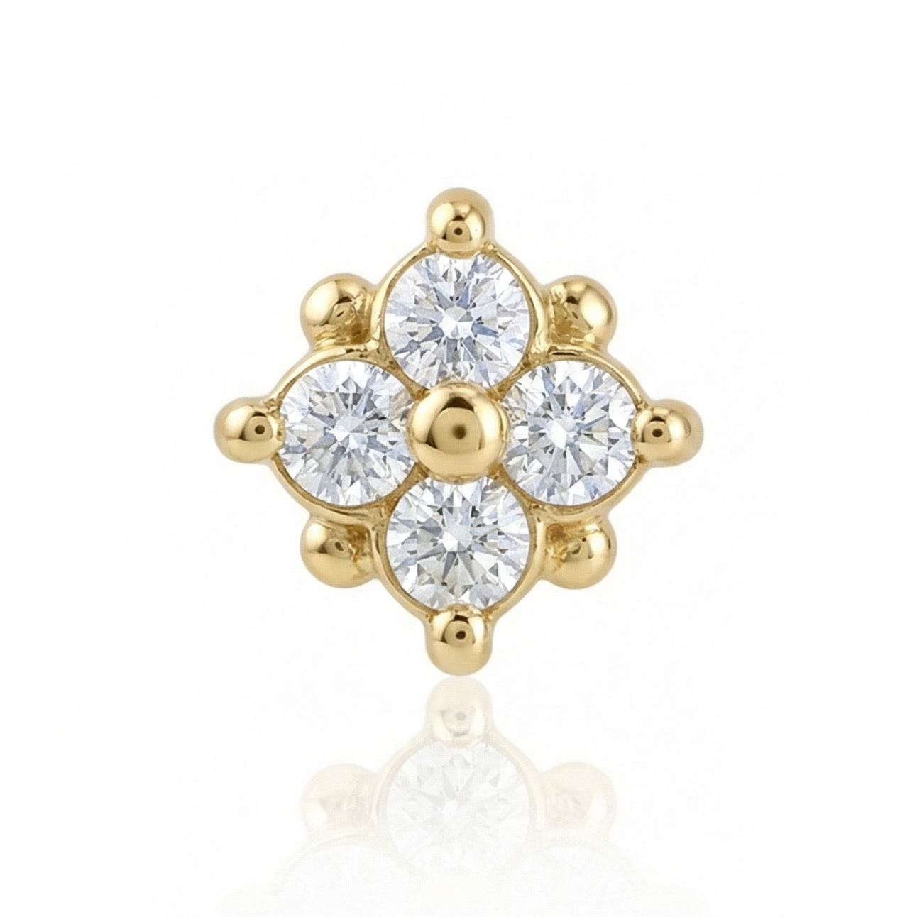 Gold earring with clear gemstones on a white background